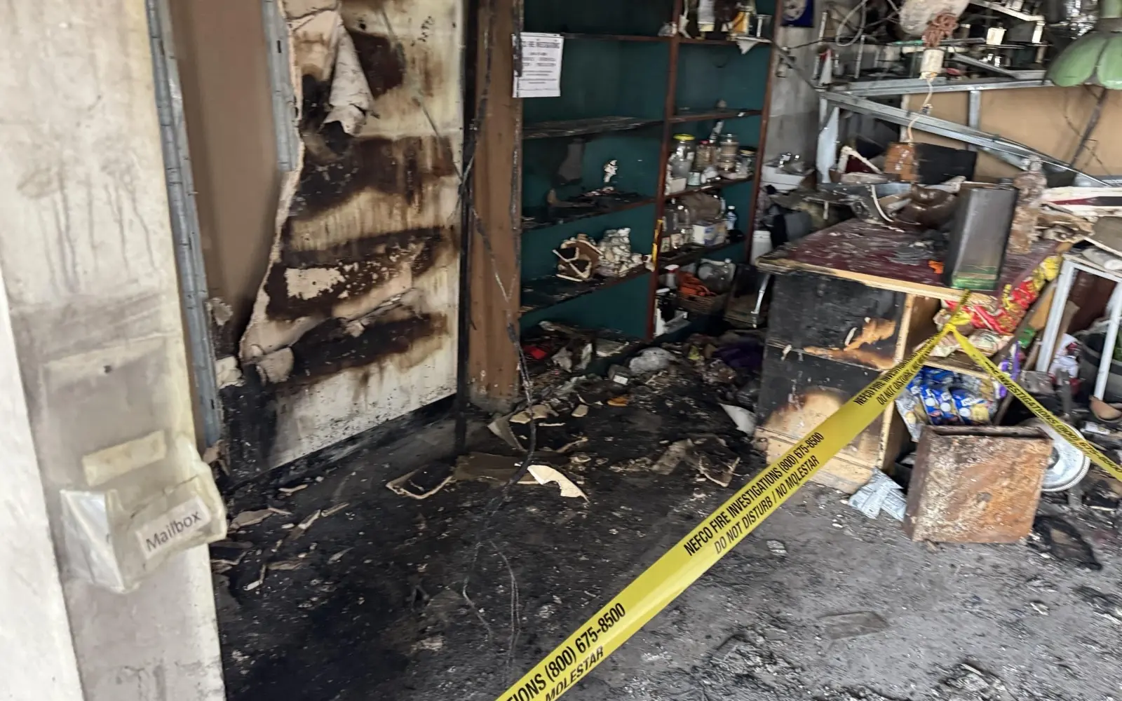 Severe fire damage to interior shelving and stored contents in a commercial building